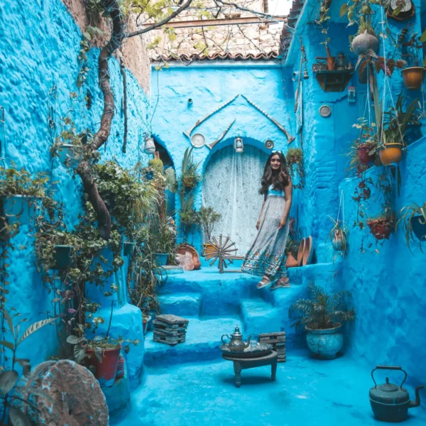 Bright blue courtyard with plants and a Moroccan tea table in Chefchaouen